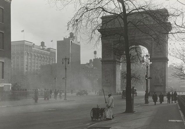 1930 â View facing south from the beginning of 5th Avenue towards Washington Square.  A street sweeper is visible in the foreground and the Washington Arch is visible behind.